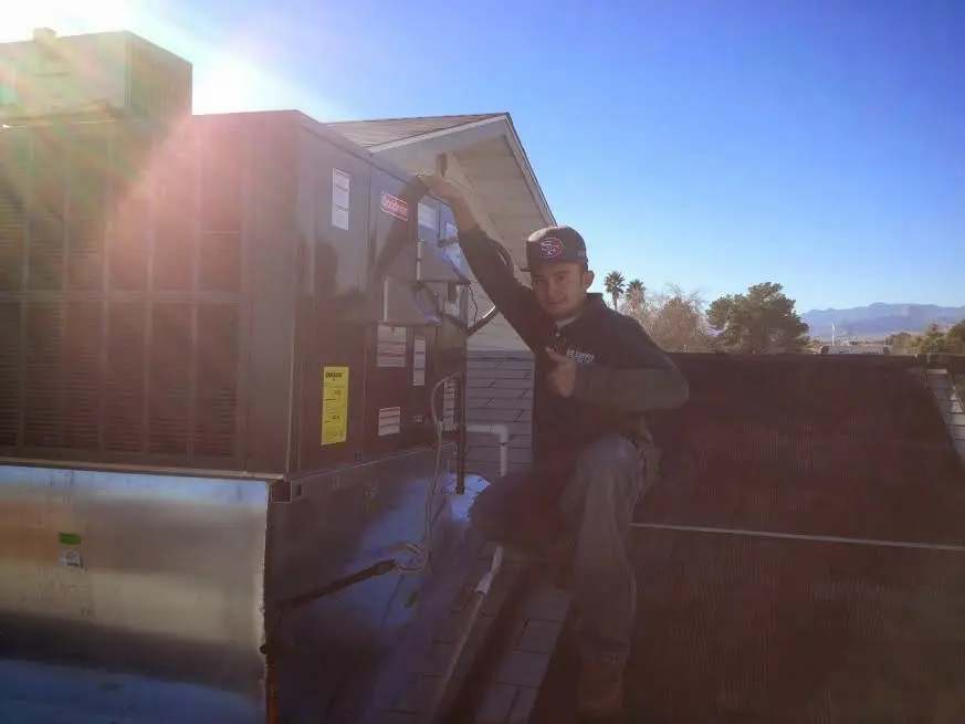 HVAC technician performing Air Duct Cleaning on a rooftop unit in Campbell